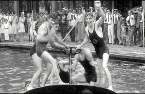 Historic photo showing people playing on a spinning top in the swimming pool at Rose Island