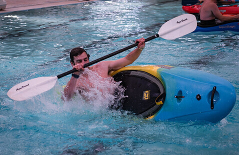 A student flips over in their kayak in the Dixon Pool.