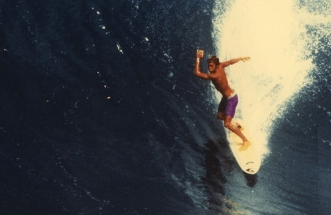 Wide shot of a surfer surfing a big wave.