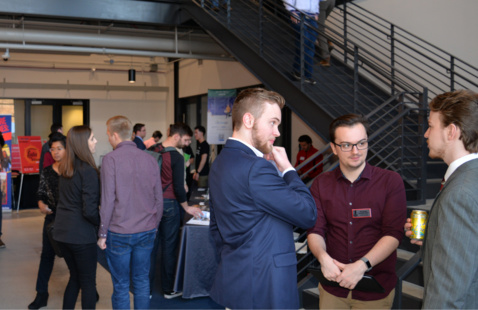 A group of people standing up and talking.
