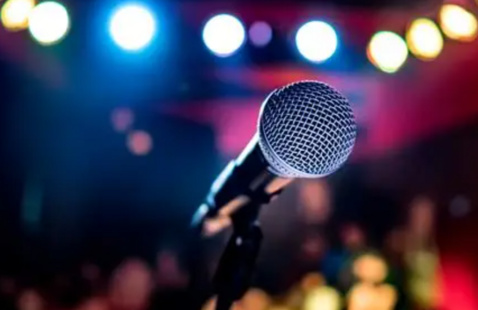 A microphone standing alone on a stage.