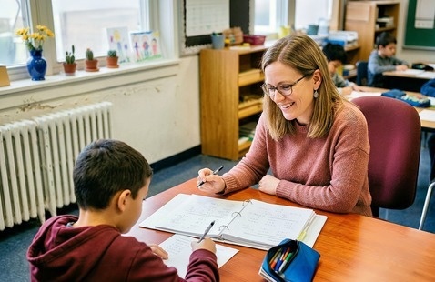 An Adult Woman works on Homework with a child 