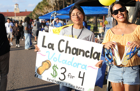 Two students selling custom sandles at fall carnival