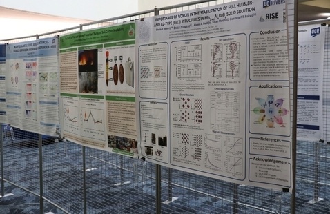 RISE/MARC poster exhibit in Orbach showing posters hung on wire racks. 