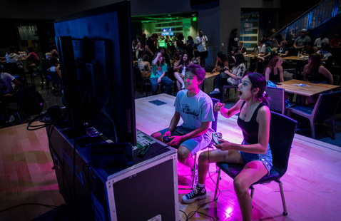 Two students playing video games in the Syndicate.