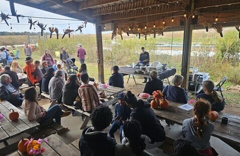 A group of people sitting at picnic tables.