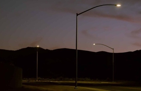 photo of dusk with mountains in background and street lights lit up