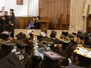Students sat in Abbey Chapel, decorated caps in view.