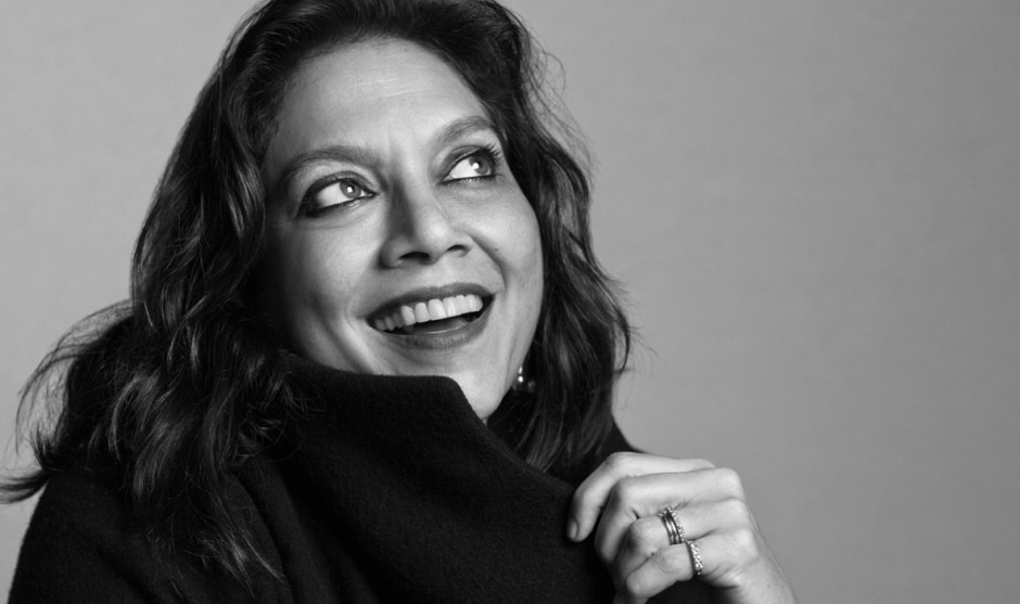 Mira Nair is shown in a black and white photograph smiling and looking up to the right.