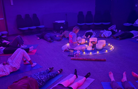 People laying down during sound bowl class in the planetarium