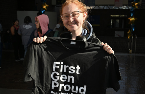 Student holding a first-gen proud t-shirt. 