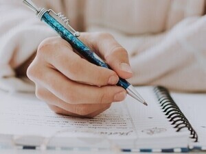 Close up of someone taking notes.