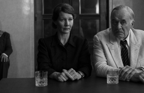 A woman and man with drinks sit at a table
