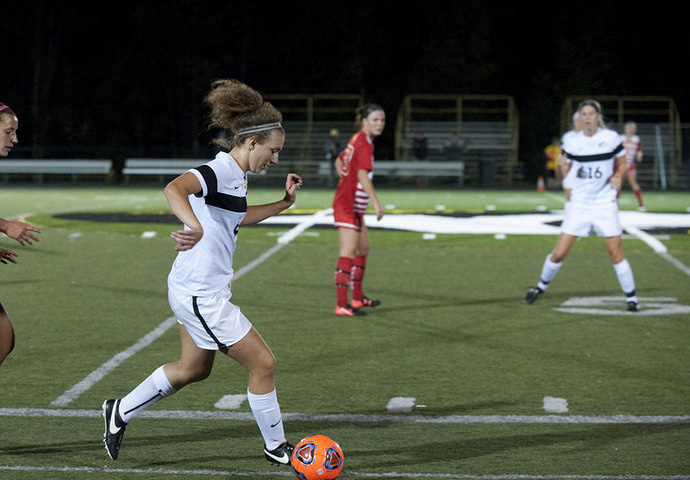 Soccer player kicking a ball down the field.