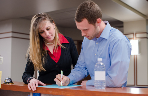 Two people looking down at a document.